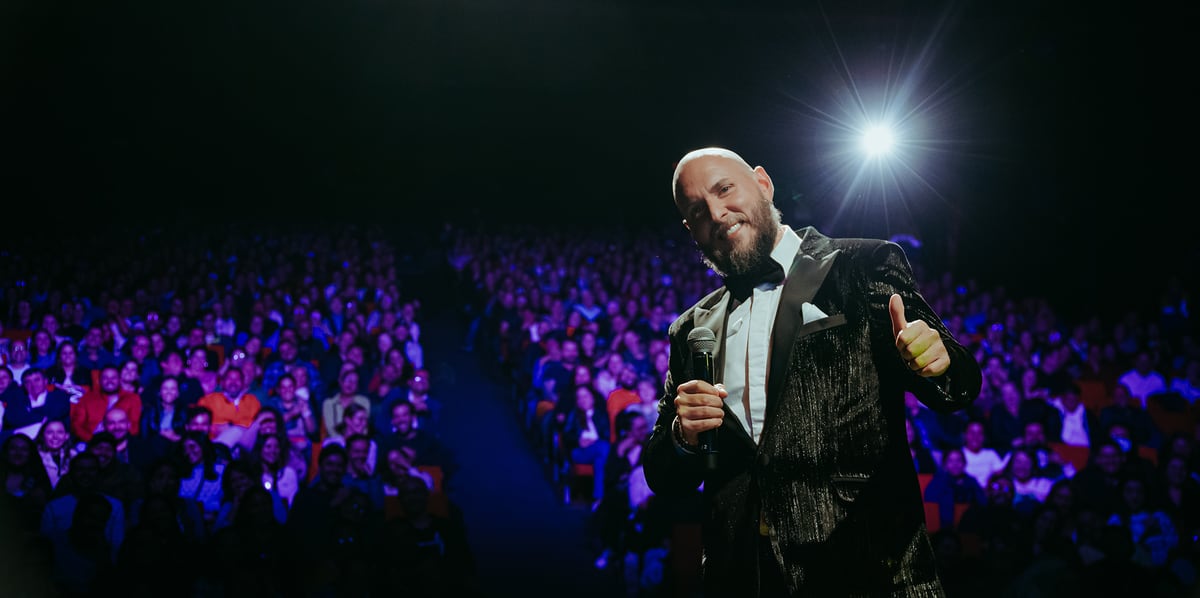 Andrés Parra en escena con micrófono frente a un teatro lleno — espectáculo 'Venga que si es pa' eso', gira final, Madrid 2026.