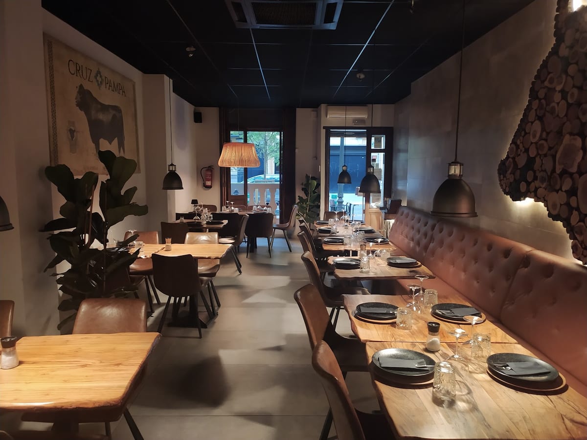 Interior de Argentino Cruz Pampa en Valencia, mostrando un ambiente refinado y platos como carnes a la brasa y empanadas argentinas — foto oficial del restaurante.